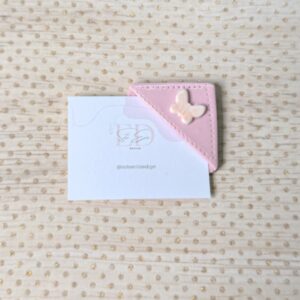 Marcapáginas en color rosa bebe con una mariposa blanca y efecto iridiscente, su forma es cuadrada