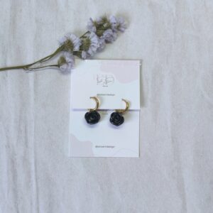 Pendientes de aro con charm de rosa en color negro, hecha a mano pétalo a pétalo, con pequeño brillo esmeralda