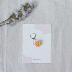 Marcador para agujas o ganchillo, con forma de rosa elaborada pétalo a pétalo en color naranja pastel
