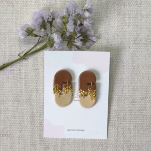 Pendientes compuesto de dos piezas asimétricas, en color marrón chocolate, color oro y beige