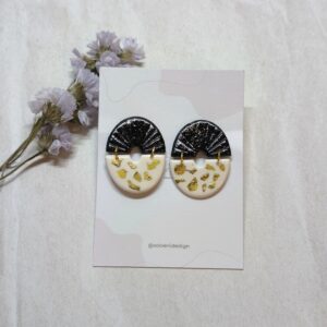 Pendientes de dos piezas enlazadas, con forma de semicírculo, una de color negro y otra de color blanca con papel de oro